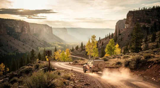 A rugged 4x4 vehicle parked alone on a remote dirt trail winding through a vast wilderness landscape at dusk, with no other vehicles or people in sight